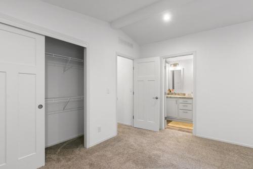 An empty bedroom with a closet and closet doors.