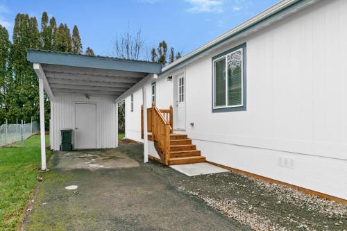 A white mobile home with steps leading to the garage.
