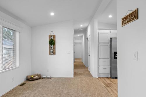 A hallway in a home with white walls and carpet.