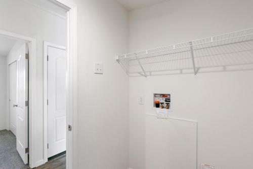 A hallway with a white closet and a door.