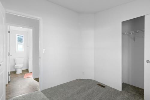 An empty room with a closet and a toilet.