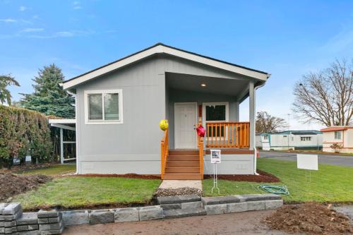 A gray mobile home with a front porch.