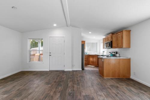 An empty kitchen with wood floors and white cabinets.