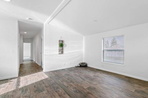 An empty room with hardwood floors and white walls.
