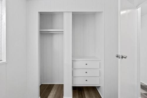 A white closet in a room with wood floors.