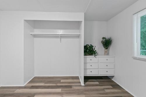 An empty room with white walls and wood floors.