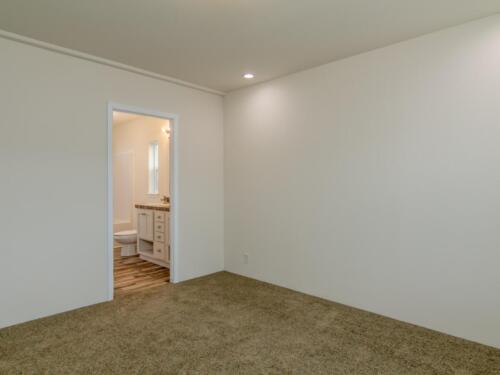 An empty room with white walls and carpet.